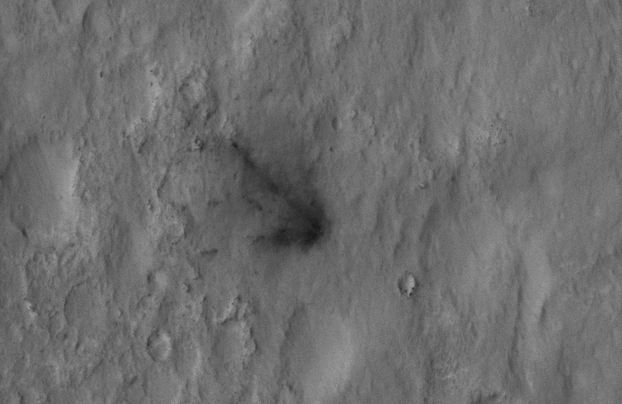 This close-up view captured by NASA Mars Reconnaissance Orbiter shows darkened radial jets caused by the impact of Curiosity sky crane, which helped deliver the rover to the surface of Mars.
