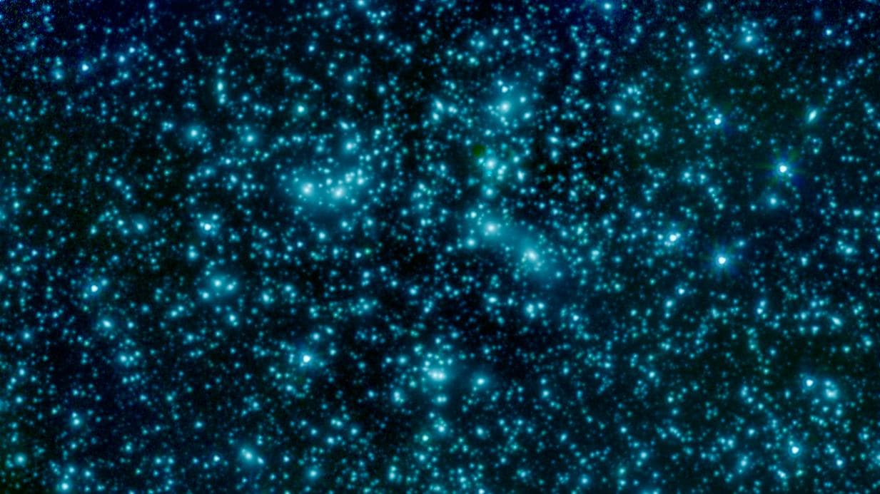 This image of galaxy cluster Abell 2744, also called Pandora's Cluster, was taken by the Spitzer Space Telescope. The gravity of this galaxy cluster is strong enough that it acts as a lens to magnify