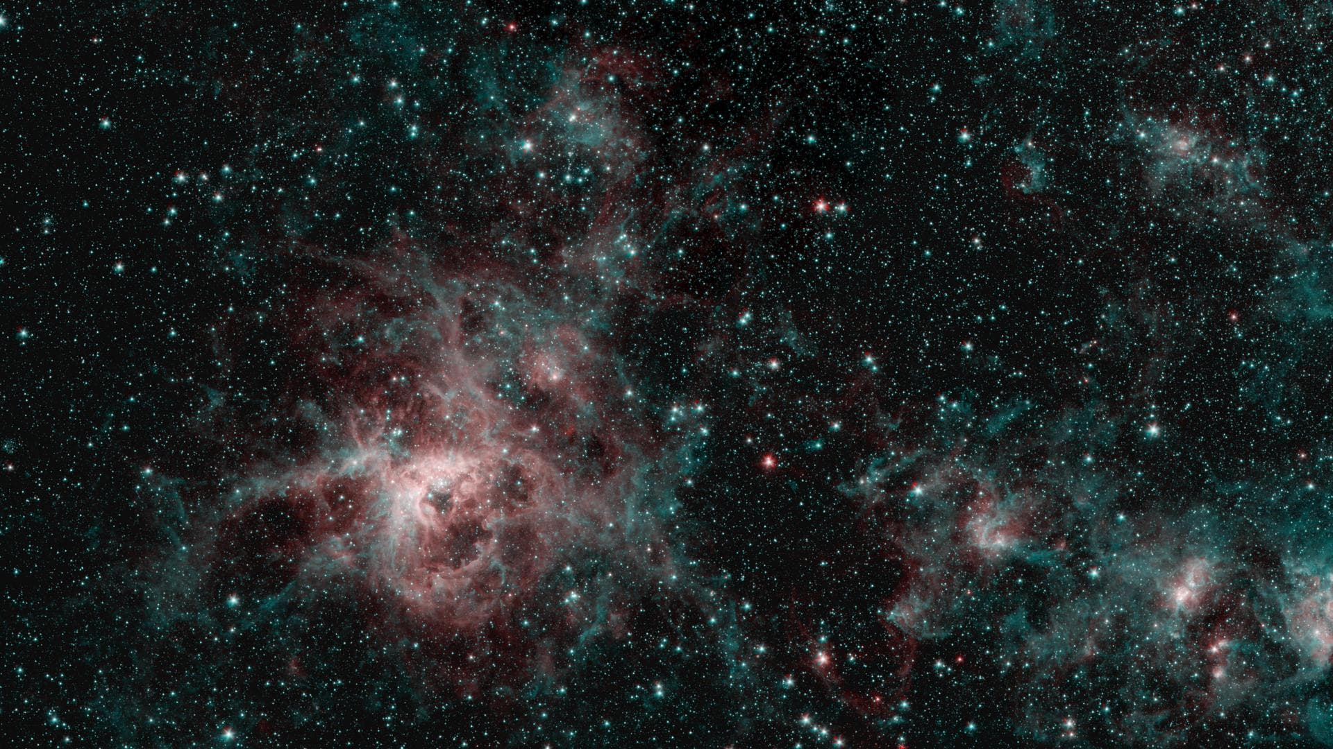 This image from NASA's Spitzer Space Telescope shows the Tarantula Nebula in two wavelengths of infrared light, each represented by a different color. The red color at the heart of the nebula shows th