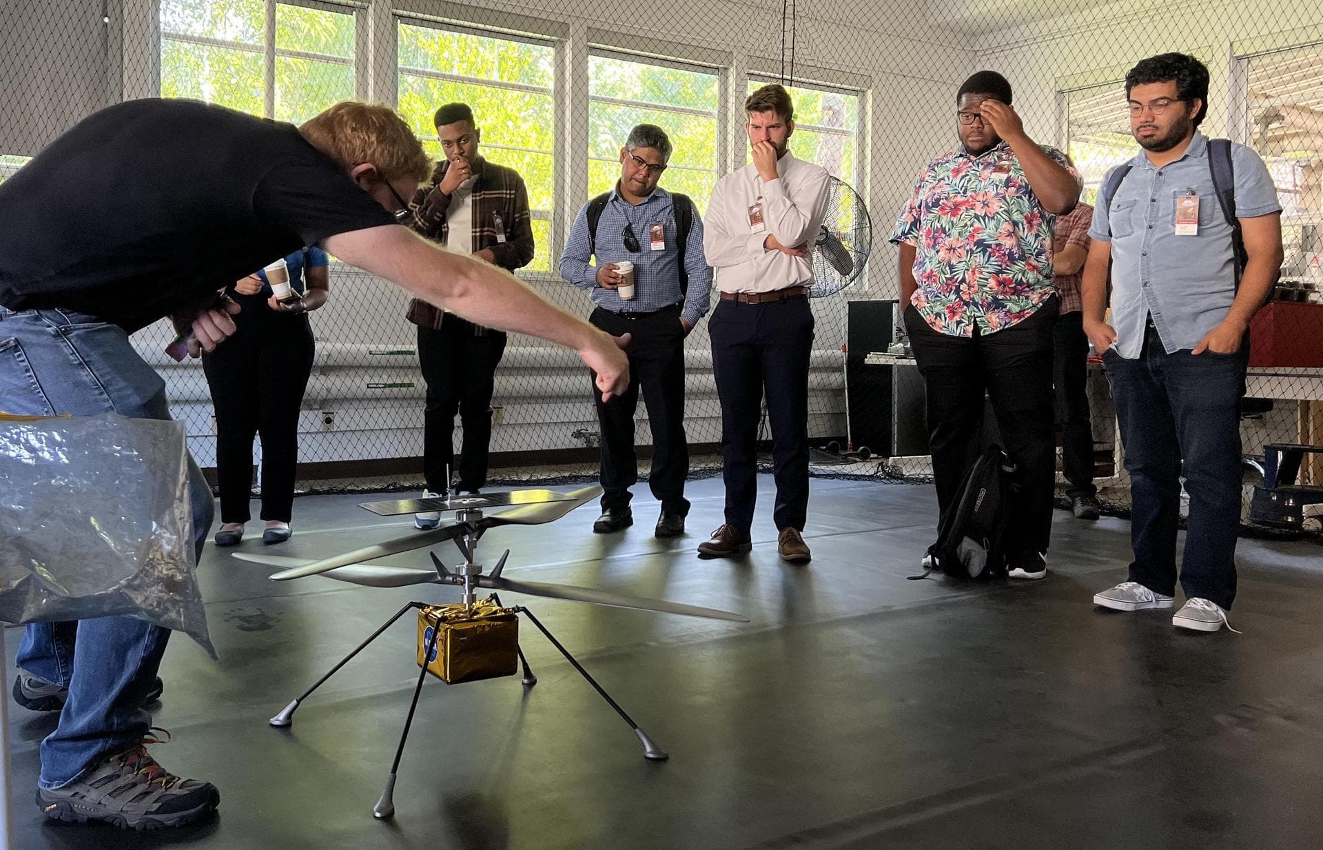 Participants in NASA's Minority Serving Institutions Space Accelerator program surround a full-scale model of NASA's Mars Ingenuity Helicopter as engineer Michael Starch discusses the mission. The gro
