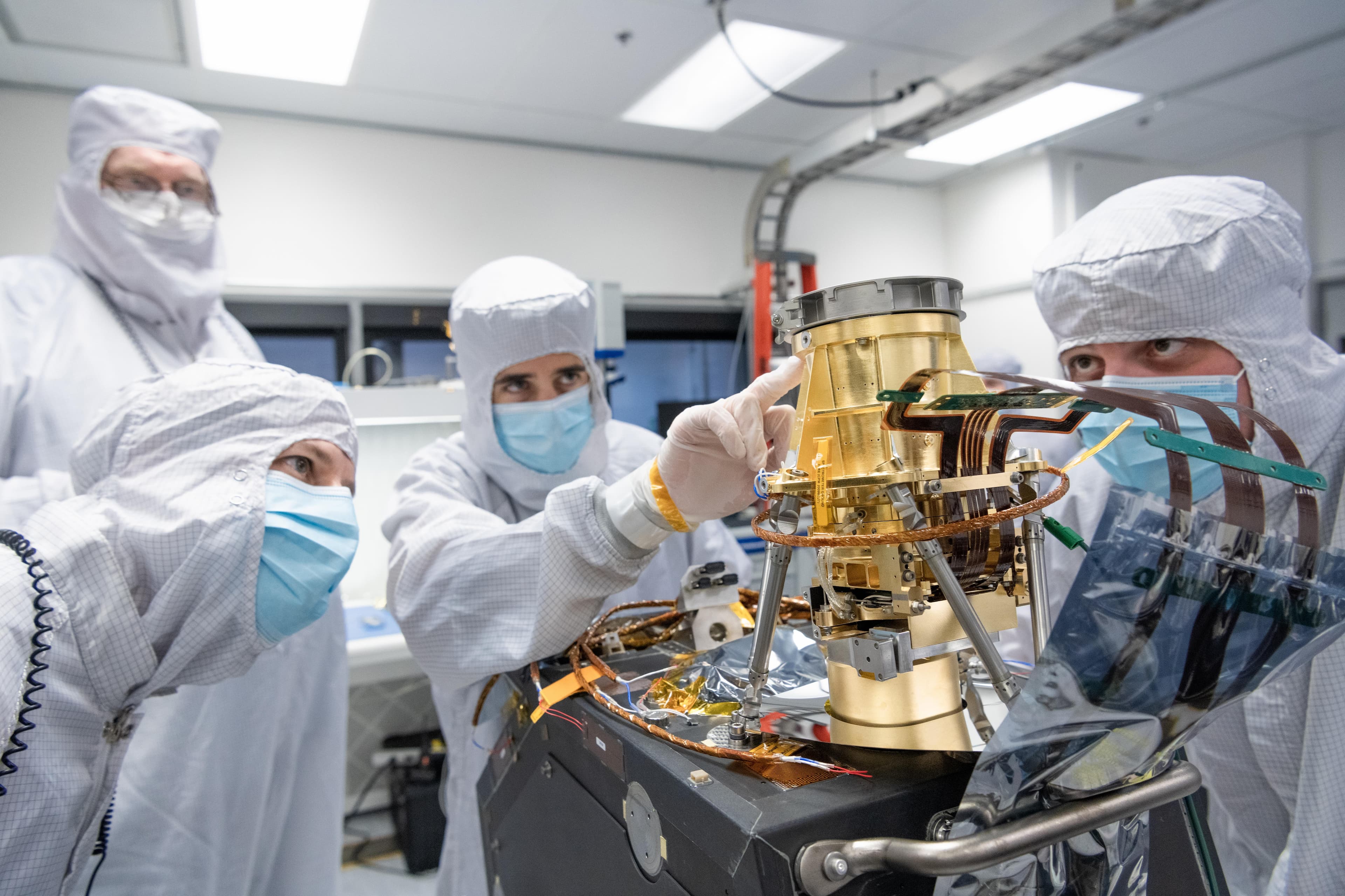 Engineers in a clean room at NASA's Jet Propulsion Laboratory in Southern California in April 2023 examine the imaging spectrometer that will ride aboard the first of two satellites to be launch