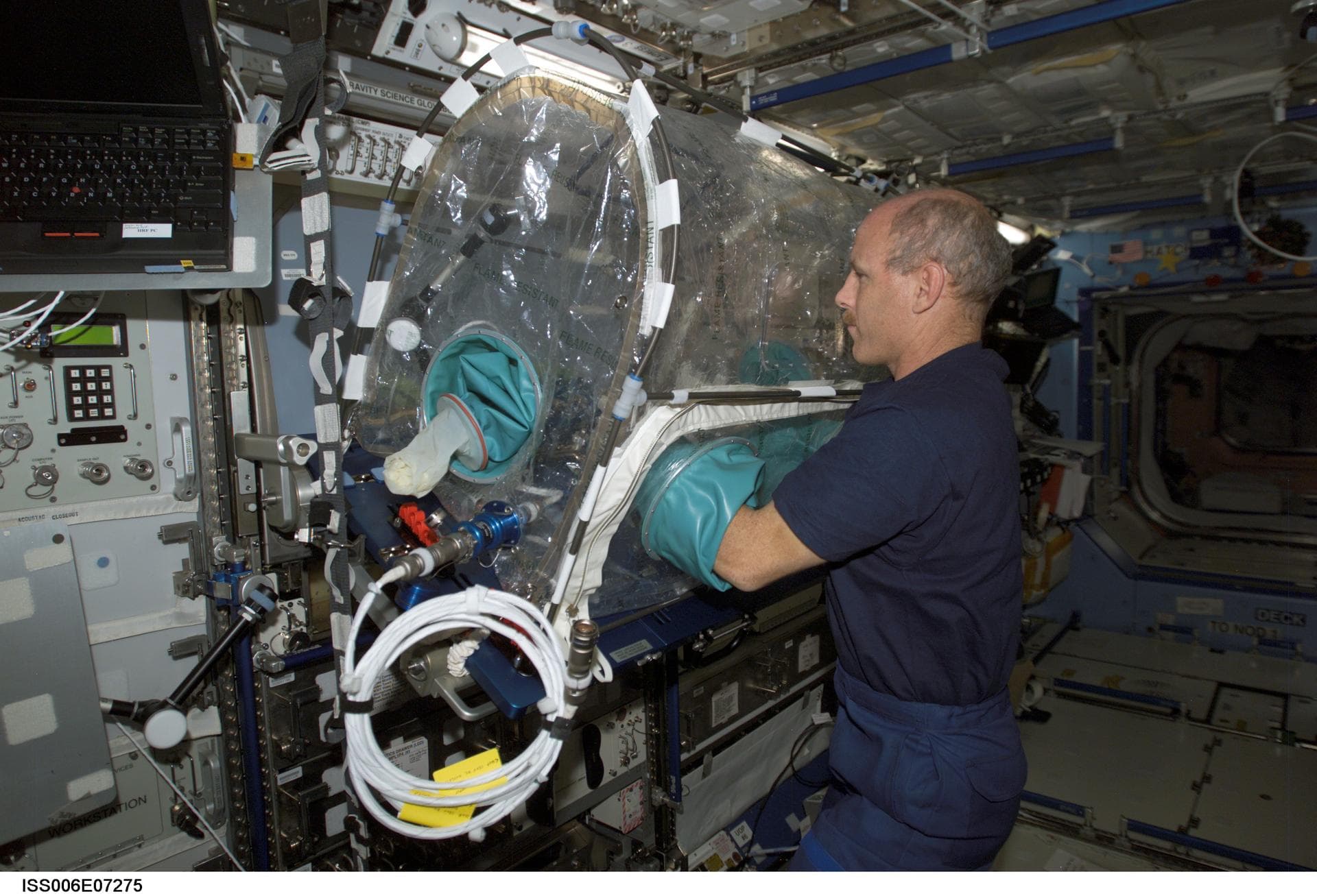ISS006-E-07275 (16 December 2002) --- Astronaut Kenneth D. Bowersox, Expedition Six mission commander, works with an experiment in a portable glovebox facility called the Maintenance Work Ar