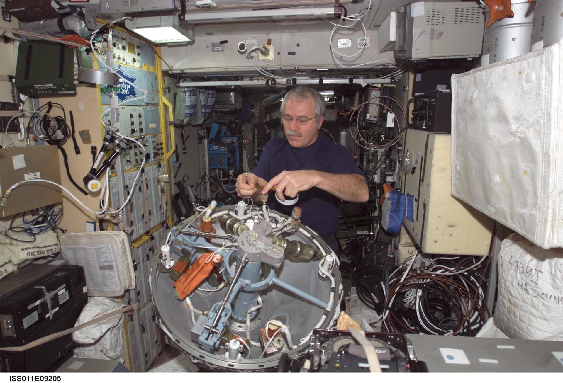 ISS011-E-09205 (19 June 2005) --- Astronaut John L. Phillips, Expedition 11 NASA ISS science officer and flight engineer, works on the dismantled probe-and-cone docking mechanism from the Progress 18