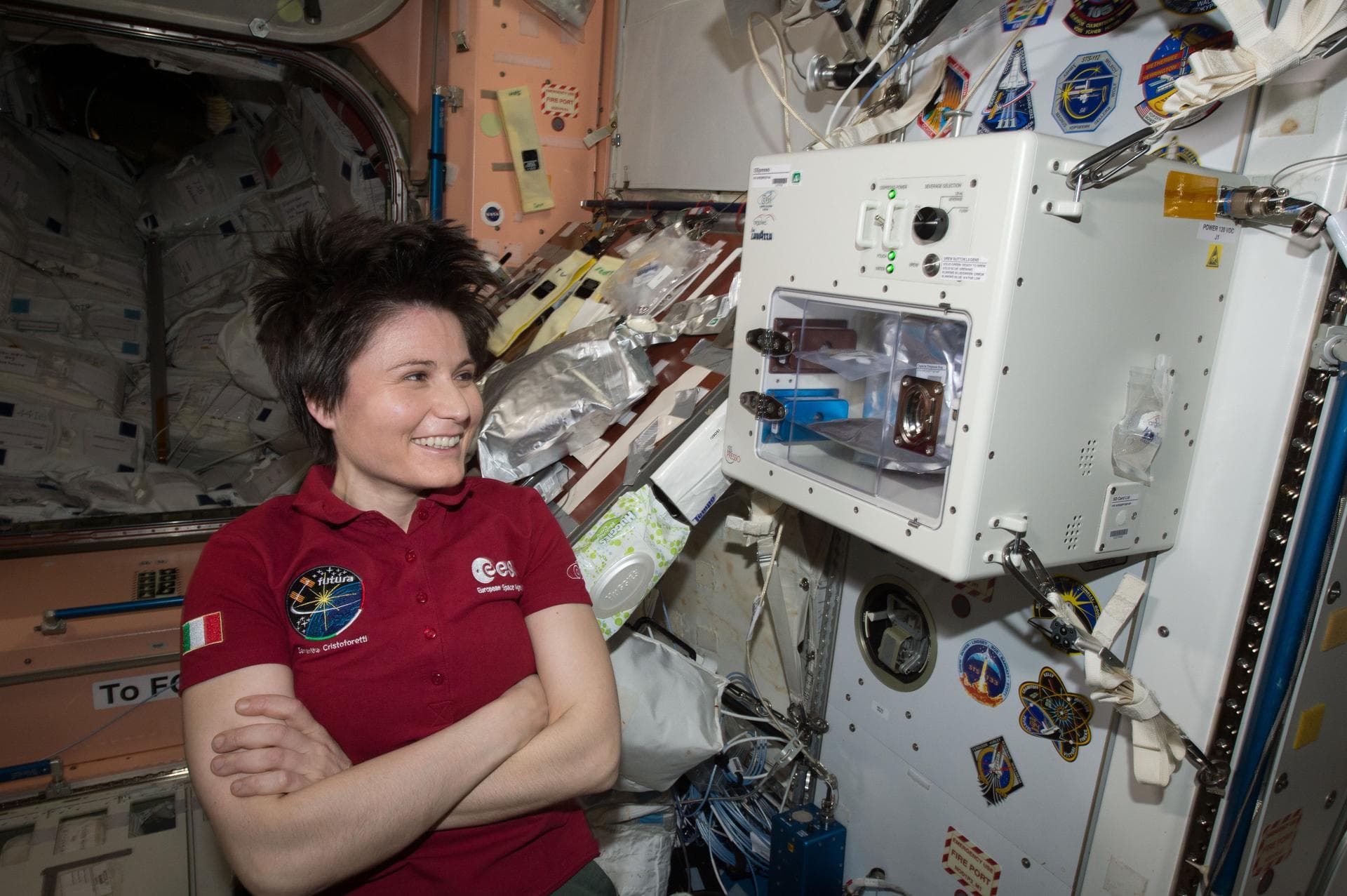 ISS043E160068 (05/03/2015) --- ESA (European Space Agency) astronaut Samantha Cristoforetti waits next to the newly installed ISSpresso machine. The espresso device allows crews to make tea, coffee, b