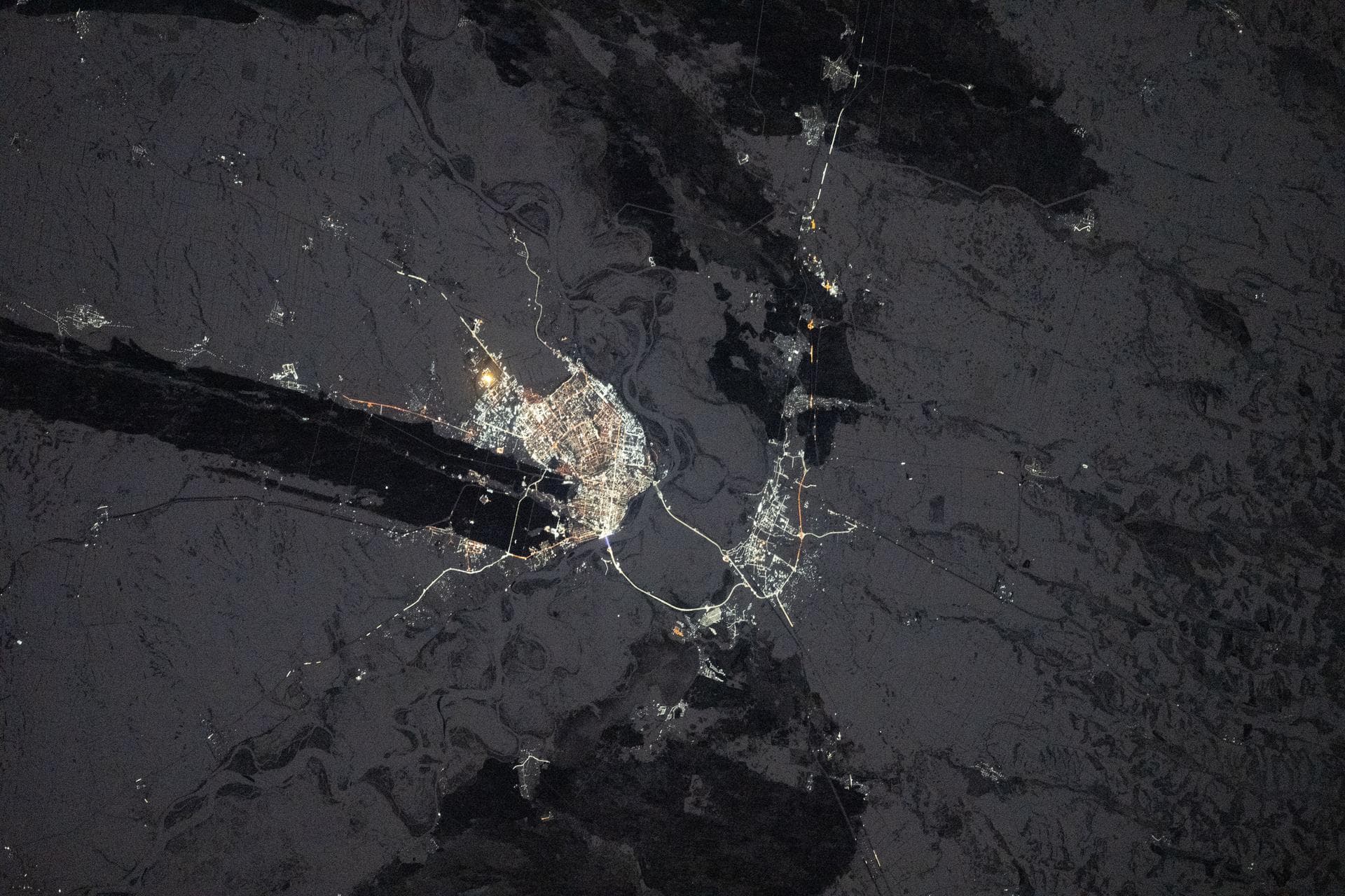 iss074e0044122 (Jan. 3, 2026) --- The city lights of Barnaul in Siberia, Russia, contrast with the extreme winter landscape. The darkened strip of land jutting out from the center of the city is part