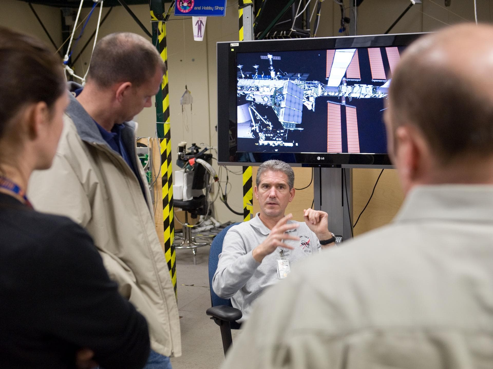 JSC2010-E-014950 (28 Jan. 2010) --- NASA astronauts Michael Good (facing camera), Garrett Reisman (right), both STS-132 mission specialists; and Tony Antonelli, pilot, use the virtual reality lab in t