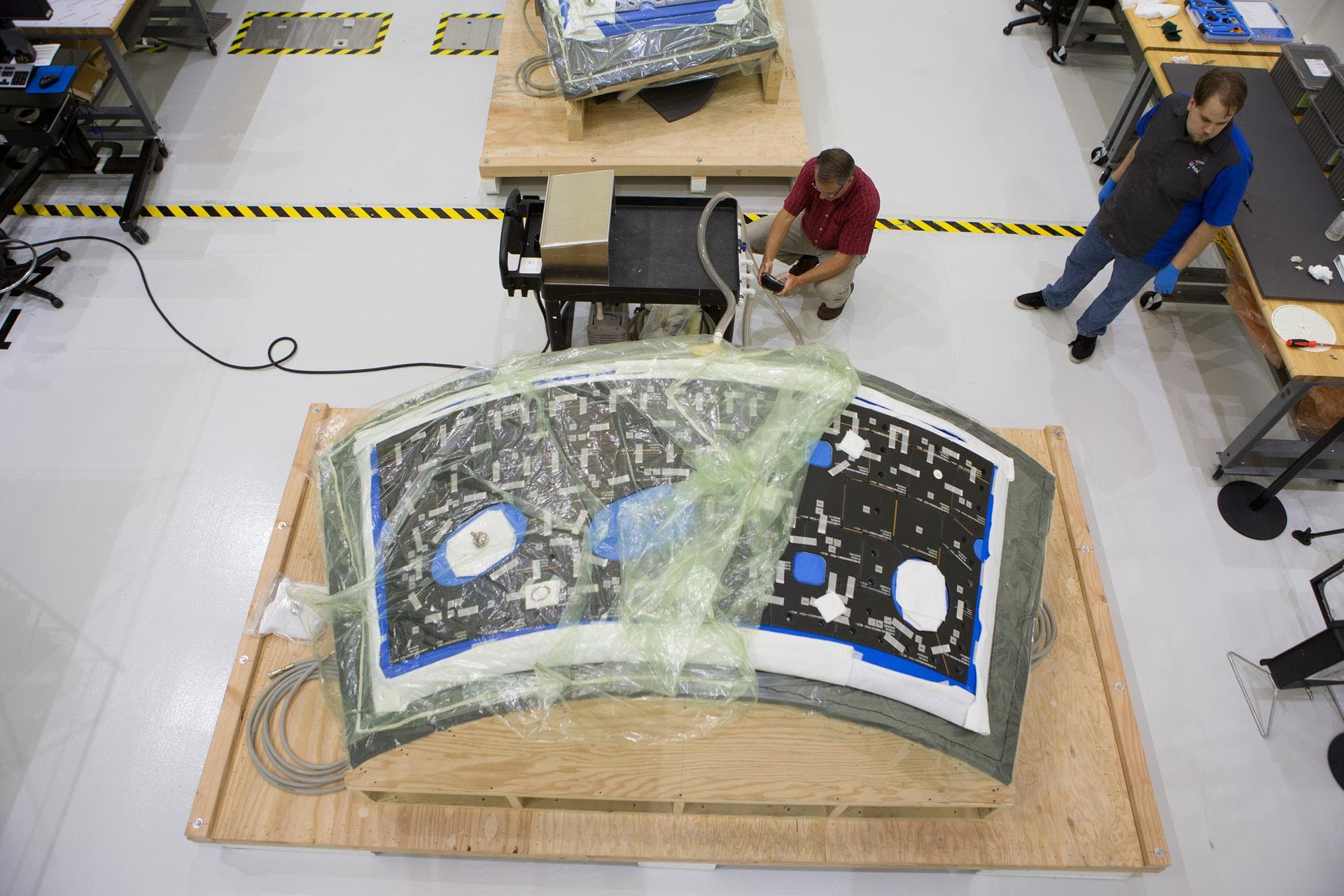 At Kennedy Space Center in Florida, technicians bond thermal protection system tiles to Orion's backshell panels on July 8, 2016...While similar to those used on the space shuttle, Orion only requires