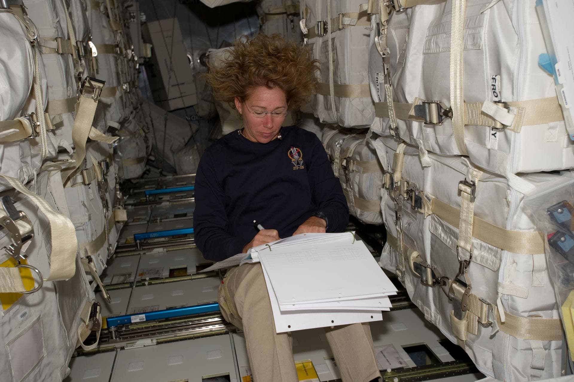S135-E-007479 (12 July 2011) --- Surrounded by supplies and spare parts in the Raffaello multi-purpose logistics module, NASA astronaut Sandy Magnus continues her role as "load master" for the joint